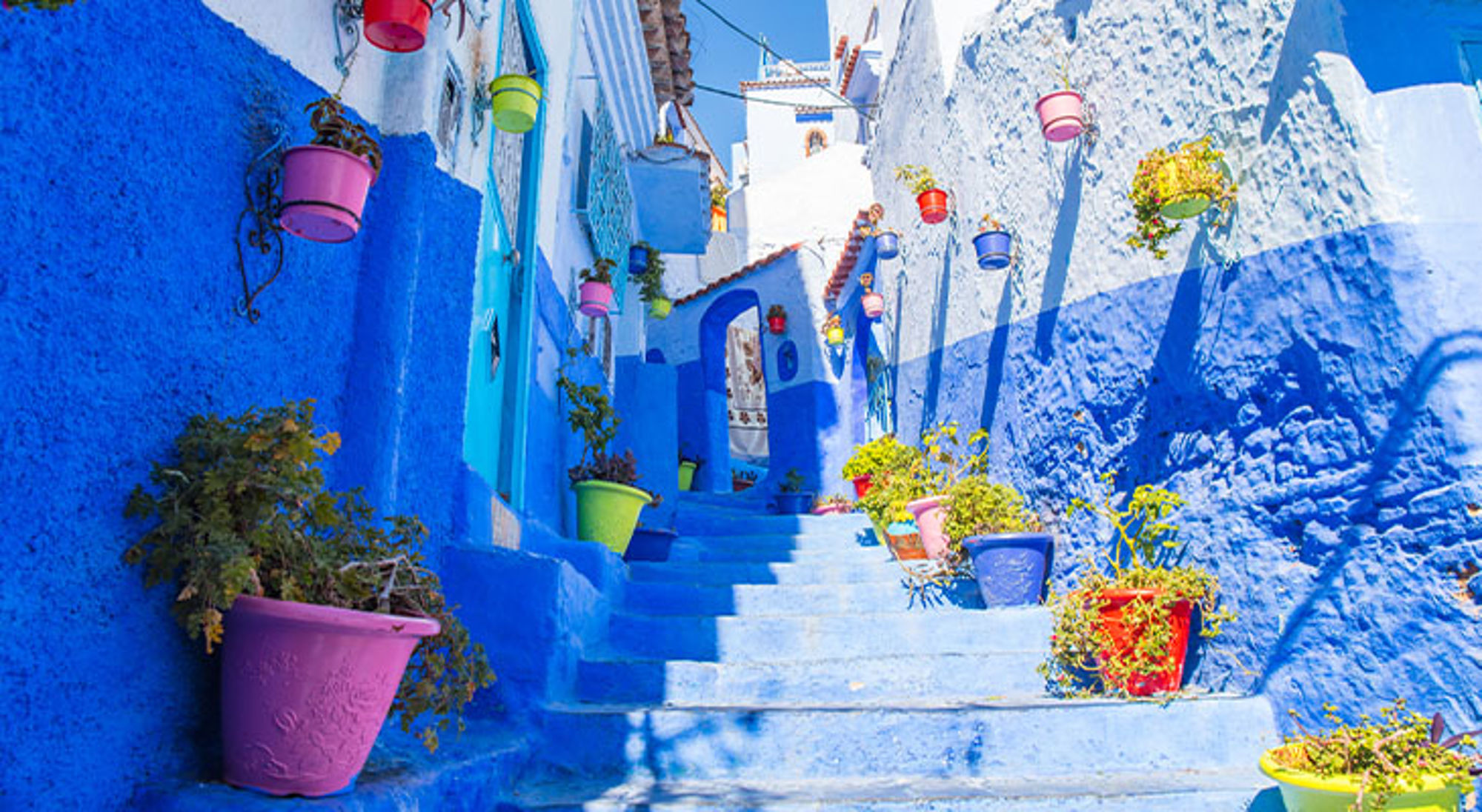 Chefchaouen Marokko Blauwe trapstraat met kleurrijke bloempotten in Chefchaouen, Marokko.