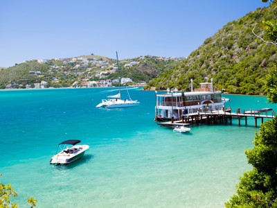 Uitzicht op de Knysna Lagoon langs de Garden Route in Zuid-Afrika, met boten en een pierrestaurant.