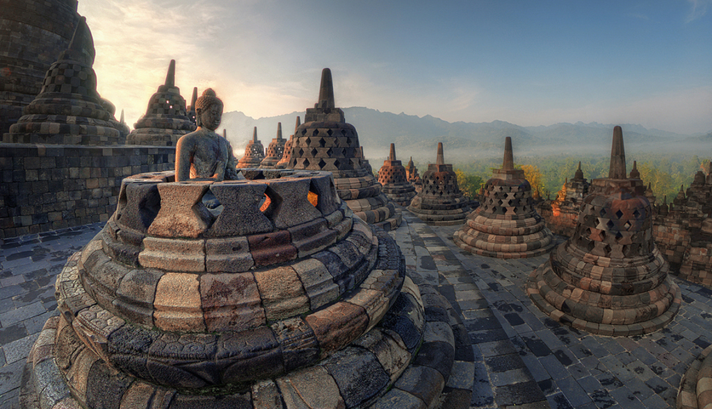 Boeddhabeeld en stoepa’s bij Borobudur op Java tijdens zonsopgang, Familiereis Java en Bali Kort.