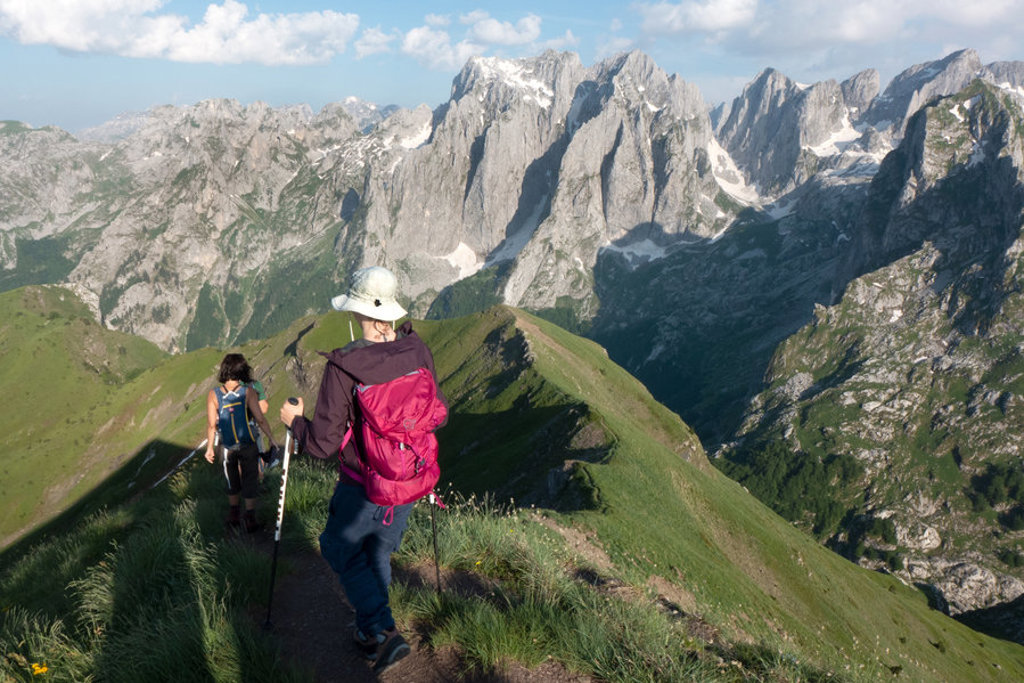 Wandelaars op bergkam tijdens wandelvakantie Peaks of the Balkan, met uitzicht op ruige bergtoppen.