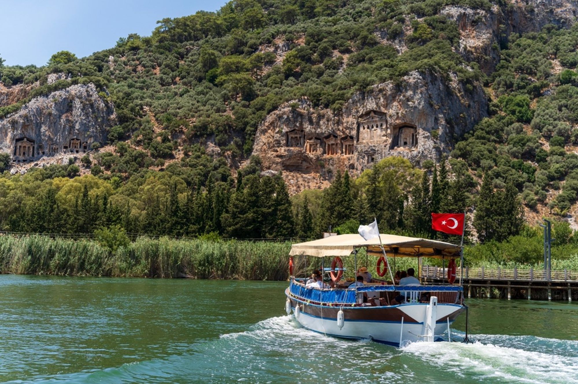 Rondvaartboot op de Dalyan-rivier langs de rotsgraven van Kaunos in Turkije.