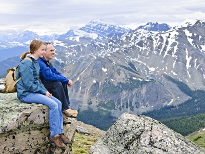 Wandelaars genieten van uitzicht op besneeuwde bergtoppen in de Canadese Rockies tijdens Route Canada.