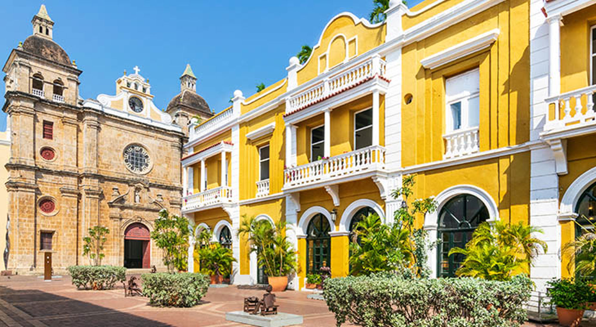 Cartagena Colombia Gele koloniale gevels en kathedraal aan Plaza de la Aduana in Cartagena, Colombia.