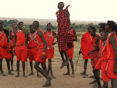 Maasai-mannen in rode kledij voeren een traditionele springdans uit tijdens de route Kenia, Tanzania en Zanzibar.