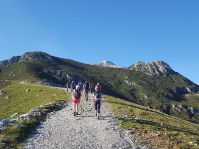 Gezinsgroep wandelt over bergpad met uitzicht op groene bergtoppen tijdens familiereis Spanje & Portugal.