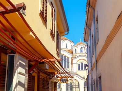 Smalle straat met kleurrijke gevels en orthodoxe kerk in Albanië, Kosovo of Noord-Macedonië.