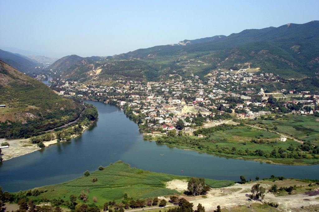 Uitzicht op Mtskheta aan de rivier de Mtkvari, met bergen op de achtergrond in Georgië.