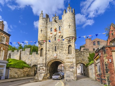 Middeleeuwse stadspoort Micklegate Bar in York, Engeland, met vlaggetjes onder een blauwe lucht.