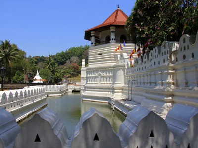 Witte tempel met gracht en rode dakkoepel in Kandy, Sri Lanka, op de route Sri Lanka en Malediven.