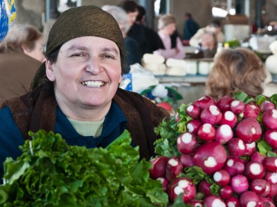 Marktvrouw op een lokale markt in Armenië met radijsjes en sla.