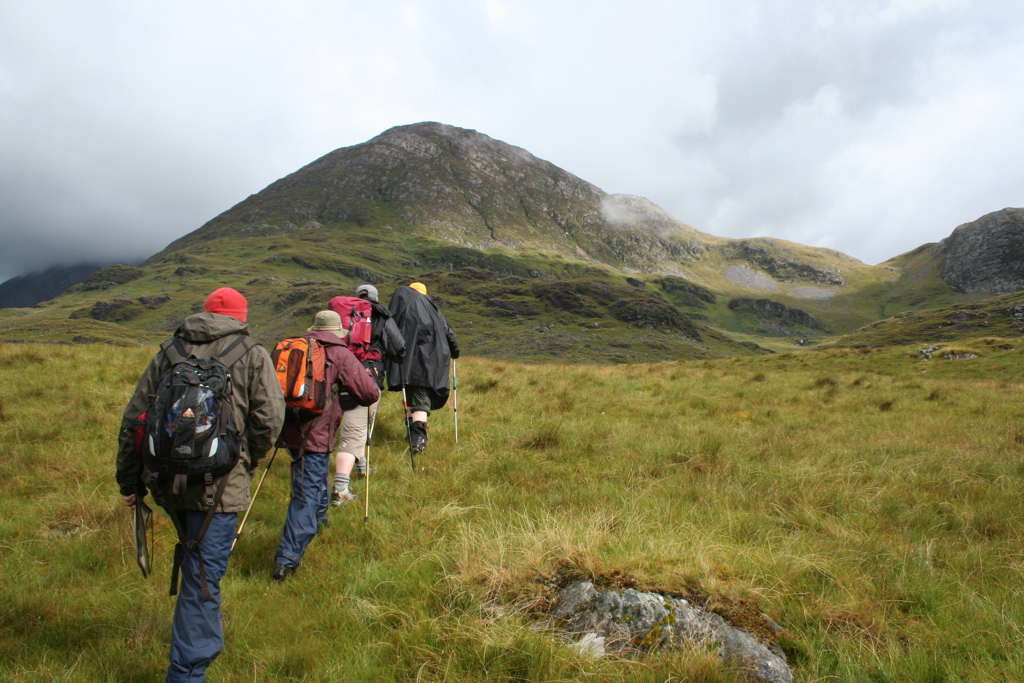 Wandelaars met rugzakken in de bergen tijdens een groepsrondreis door Noord-Ierland en Ierland.