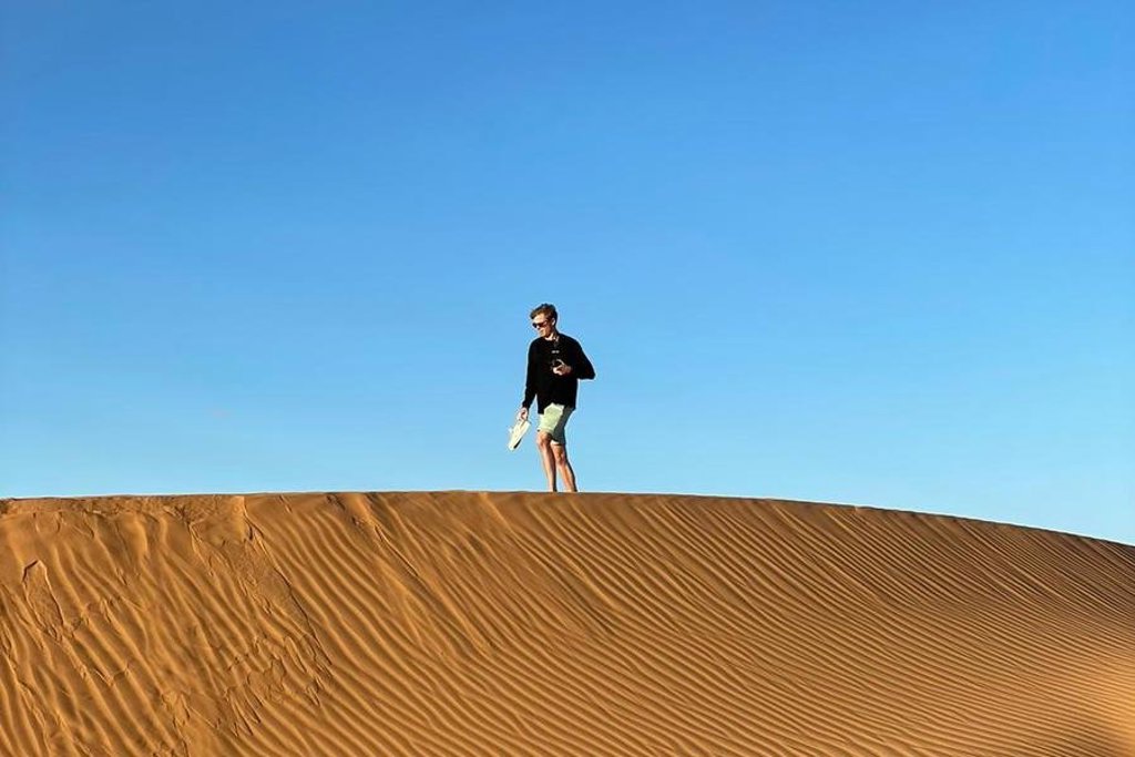 Groepsrondreis Marokko Totaal met uitzicht op een minaret en stad bij zonsondergang.