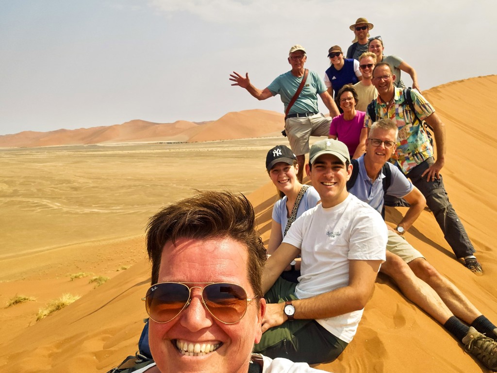 Groepsrondreis Zuidelijk Afrika: kampeergroep op zandduin in de Namibwoestijn tijdens overlandreis Kaapstad–Victoria Falls.