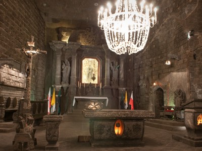 Interieur van de zoutmijnkapel in Wieliczka met altaar, beelden en kroonluchter.