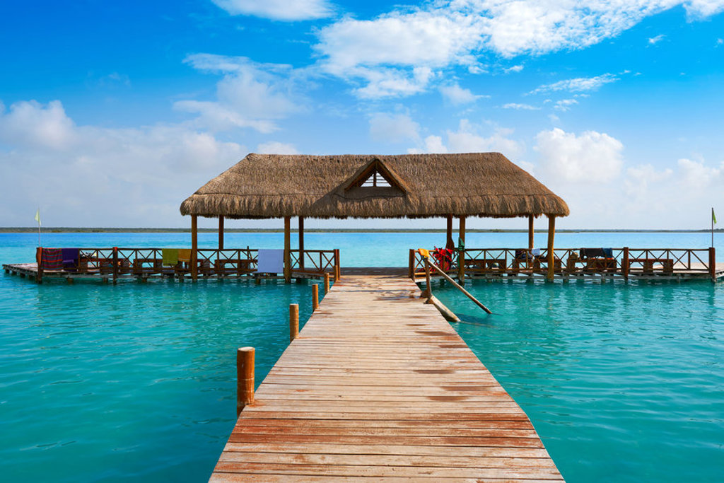 Houten steiger met rieten paviljoen aan een turquoise meer tijdens groepsrondreis Mexico, Guatemala en Honduras.