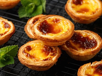 Versgebakken pastéis de nata, Portugese custardtaartjes, op een rooster.
