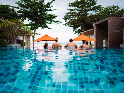 Gezin ontspant in een infinitypool bij een strandresort in Thailand tijdens de 15-daagse familiereis Thailand Hoogtepunten.