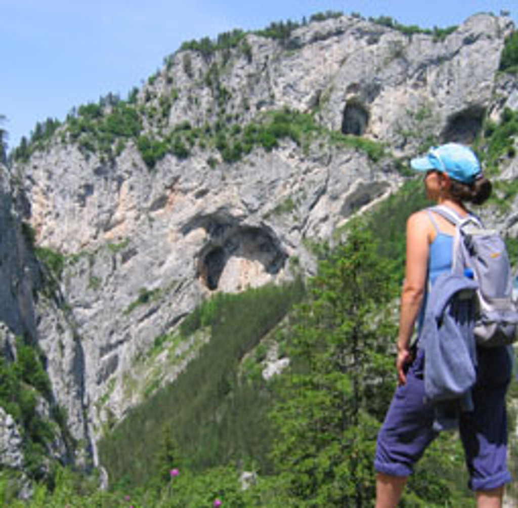 Wandelaar met rugzak kijkt uit op rotsachtige bergen in de Bulgaarse Balkan tijdens een wandelvakantie in Bulgarije.