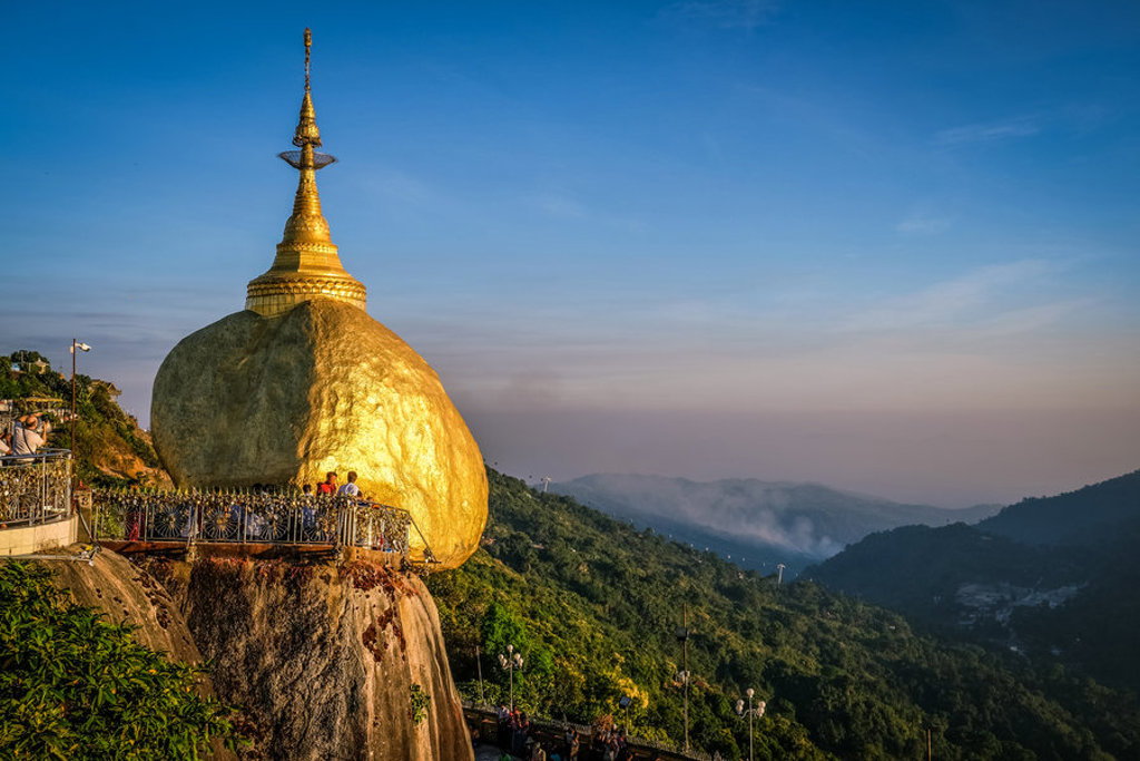 Gouden Rots met pagode bij Kyaiktiyo in Myanmar, uitkijkend over groene heuvels bij zonsondergang.