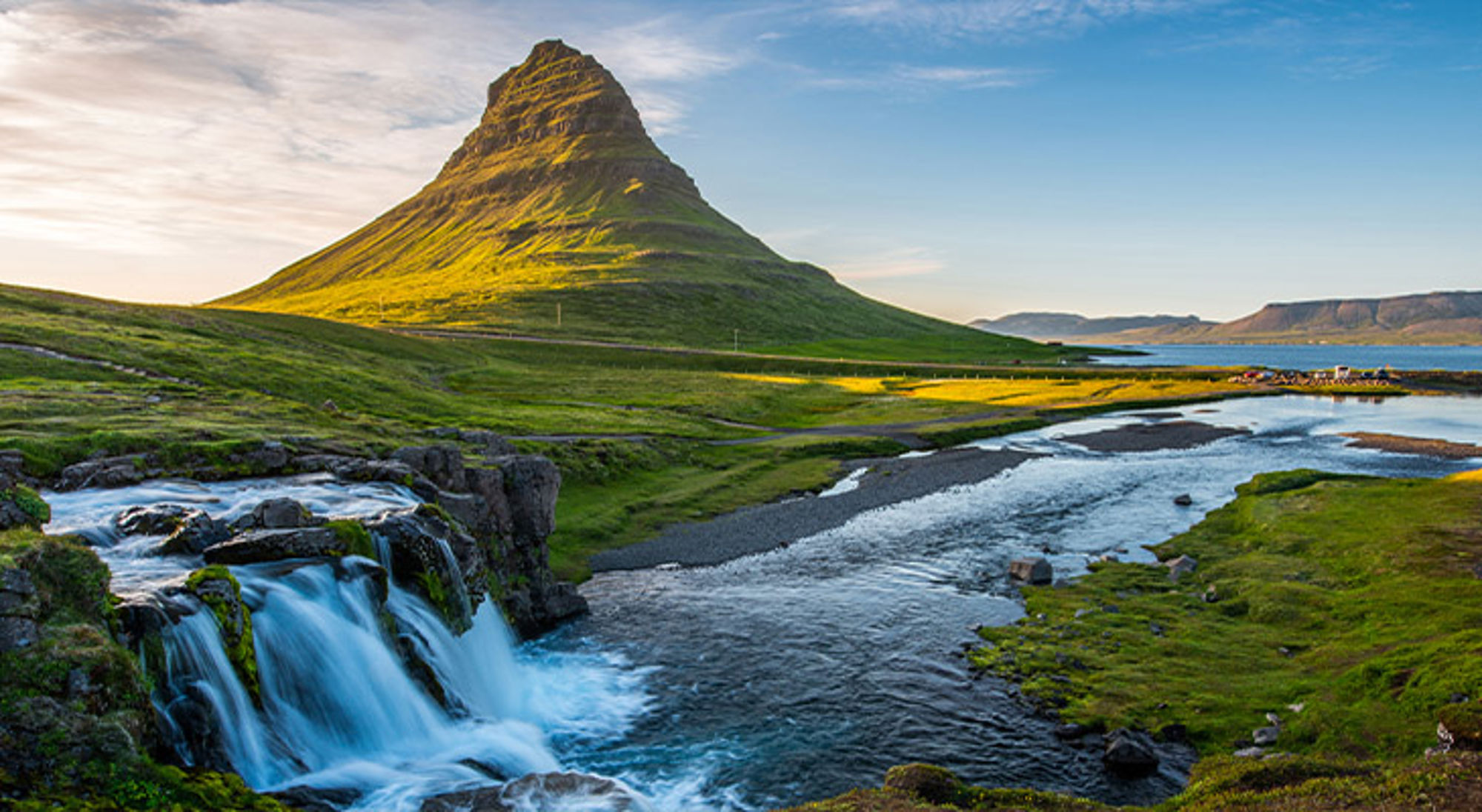 IJsland Groene berg Kirkjufell met waterval en rivier bij zonsondergang op IJsland.