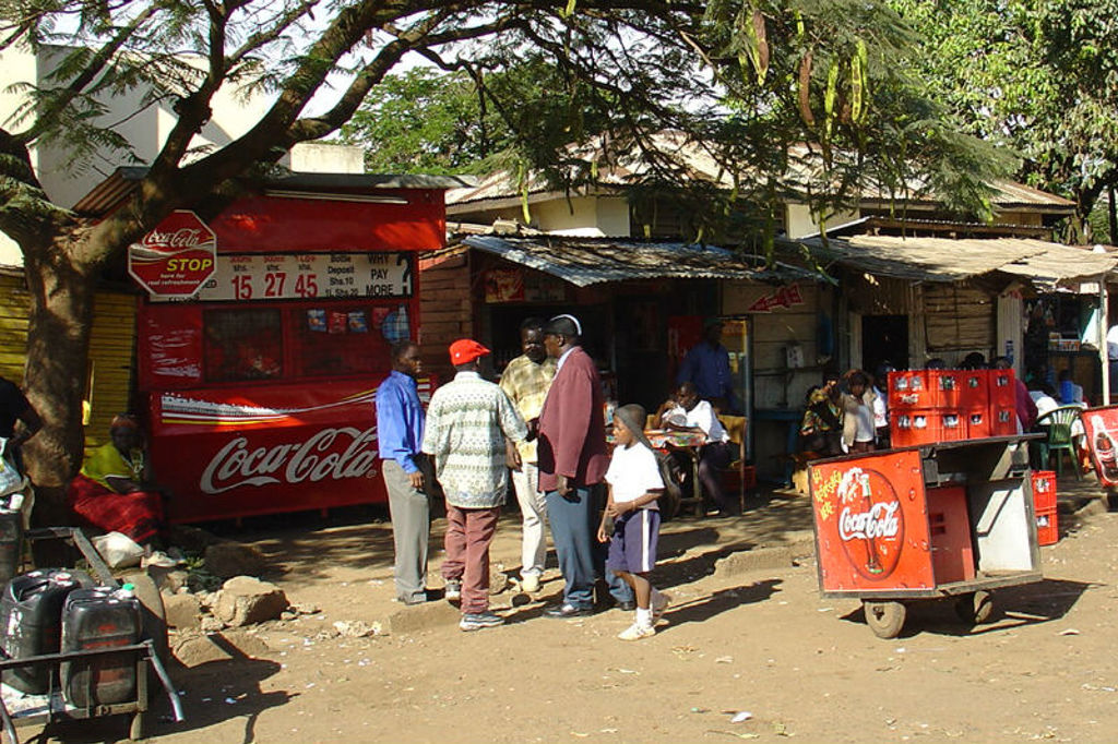 Straatbeeld in Kenia met mensen bij een kiosk en Coca-Cola kar, tijdens een groepsrondreis Kenia, Tanzania en Zanzibar.