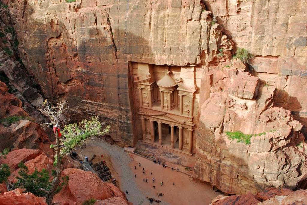 Groepsrondreis Jordanië: reizigers in de woestijn bij een bedoeïenenkamp met tenten en kamelen.