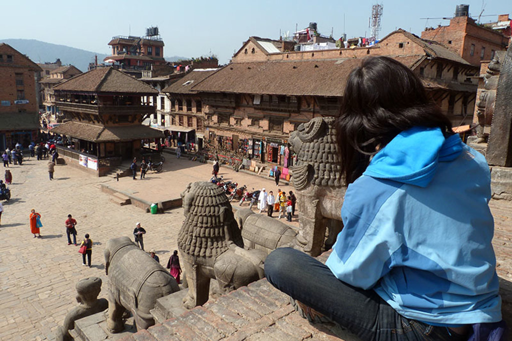 Reiziger kijkt uit over Durbar Square in Bhaktapur, Nepal, tijdens groepsrondreis Noord-India en Nepal.