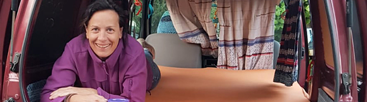 Reisbegeleidster Brenda in haar camper, met mok in de hand, als thuisblijftip om Azië minder te missen.