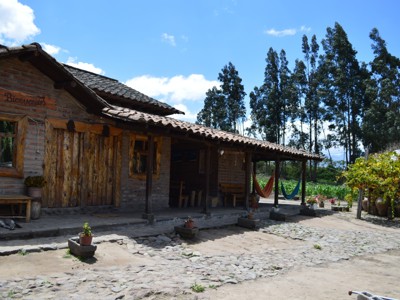 Traditionele hacienda met veranda en hangmatten in het Andeslandschap van Ecuador tijdens de 22-daagse route.