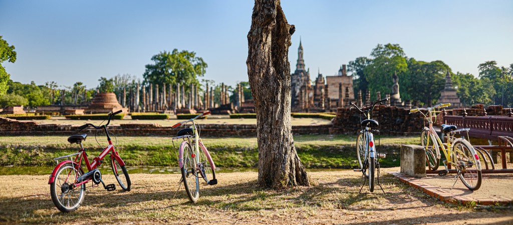 Fietsen bij de tempelruïnes van Sukhothai tijdens een familiereis in Thailand Noord en Zuid.