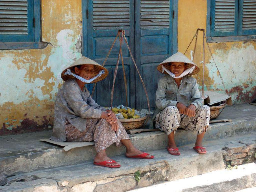 Vader en kind kijken uit over groene rijstvelden in Vietnam tijdens een familiereis.