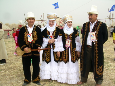 Kirgizische mannen en vrouwen in traditionele kleding tijdens een festival op de Route Kirgistan.