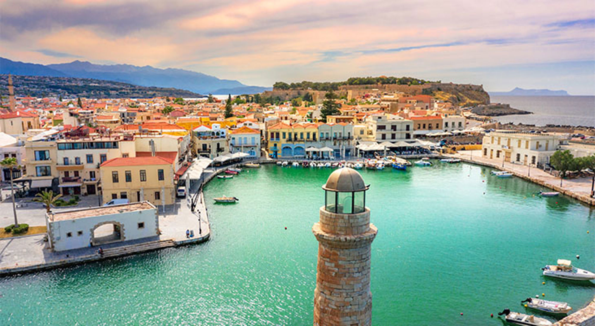 Kreta Uitzicht op de Venetiaanse haven van Rethymnon op Kreta, met vuurtoren, kleurrijke huizen en boten.