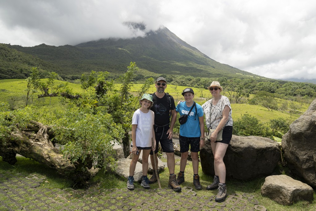 Gezin wandelt in groen landschap met vulkaan op de achtergrond tijdens familiereis Costa Rica.