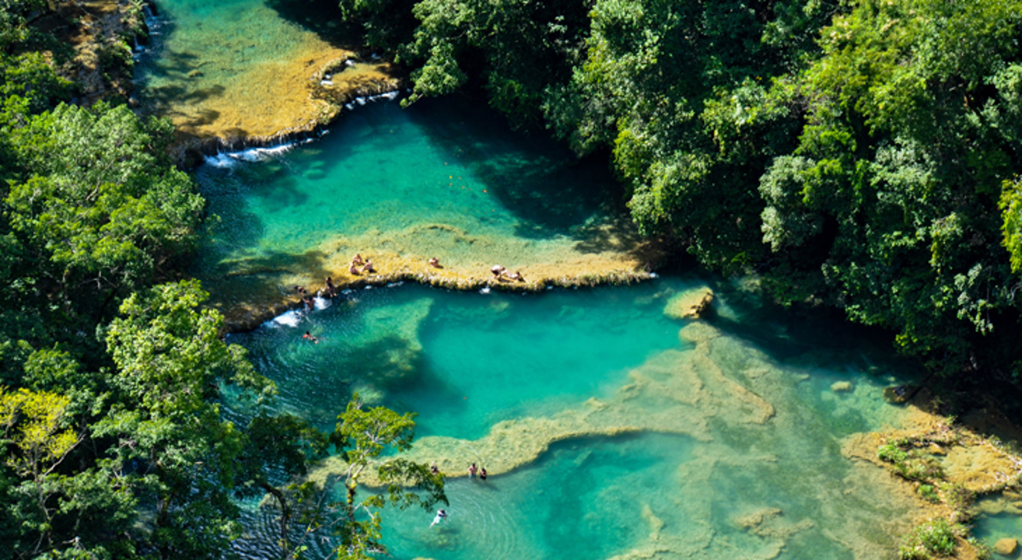 Semuc Champey in Guatemala turquoise natuurlijke zwembaden en watervalletjes in een groene jungle.