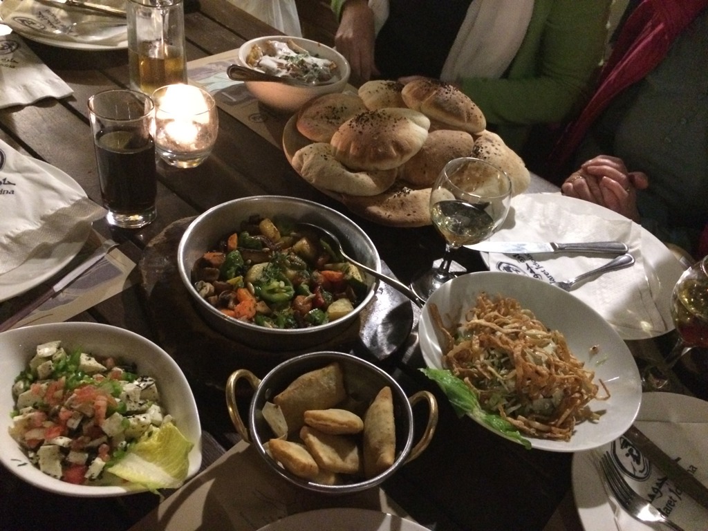 Gezellige tafel met lokale mezze, salades en vers brood tijdens groepsrondreis Israël, Palestijnse gebieden en Jordanië.