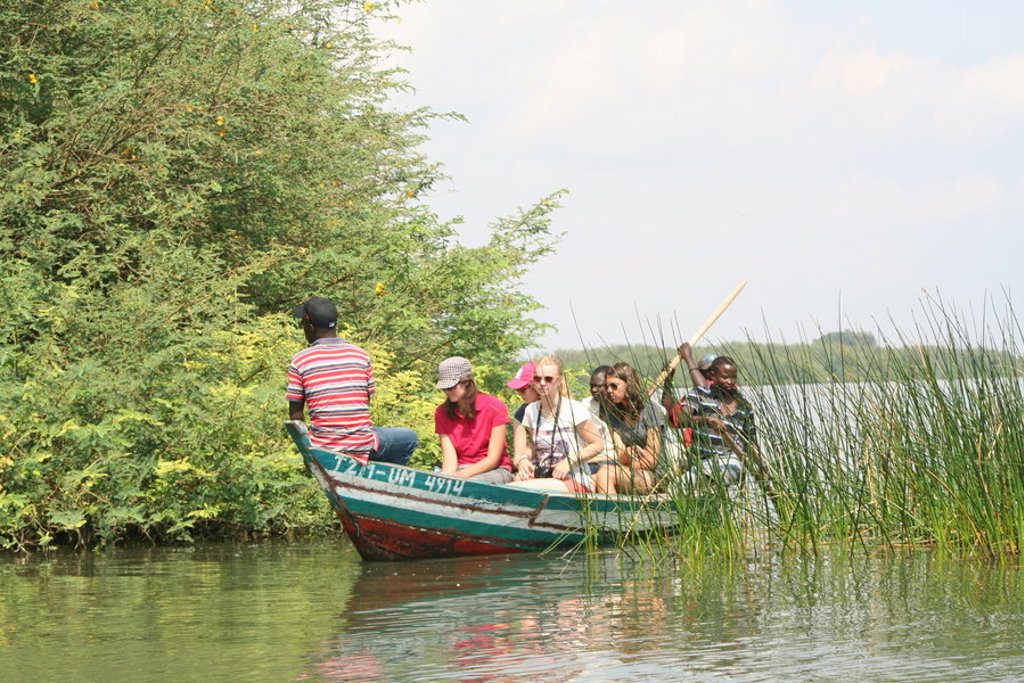 Boottocht met reizigers door rietvelden op een meer tijdens groepsrondreis Kenia, Tanzania en Zanzibar.