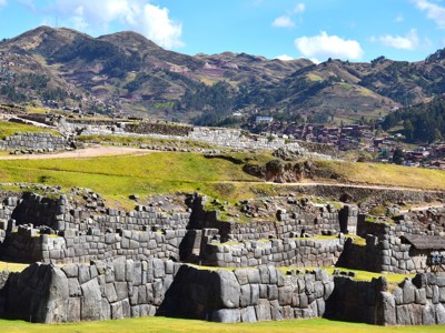 Ruïnes van Sacsayhuamán bij Cusco, Peru, met terrassen en Andesbergen op de achtergrond.