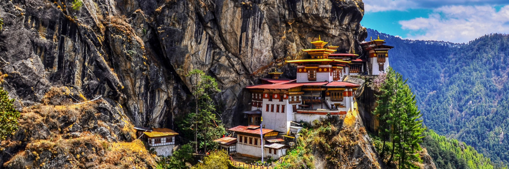Taktshang-klooster (Tiger’s Nest) tegen een steile rotswand in Bhutan, met uitzicht op de Himalaya.