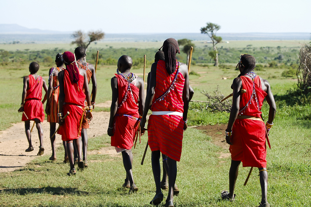 Maasai wandelen over de savanne in Kenia tijdens familiereis Kenia en Tanzania.