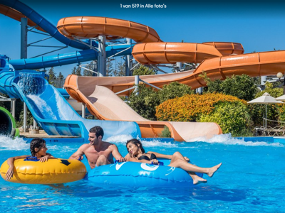 Waterpark op Cyprus met glijbanen en mensen op opblaasbanden in het zwembad.