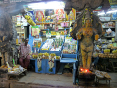 Marktkraam bij een hindoetempel in Zuid-India met offerbloemen, fruit en een beeld van Ganesha.