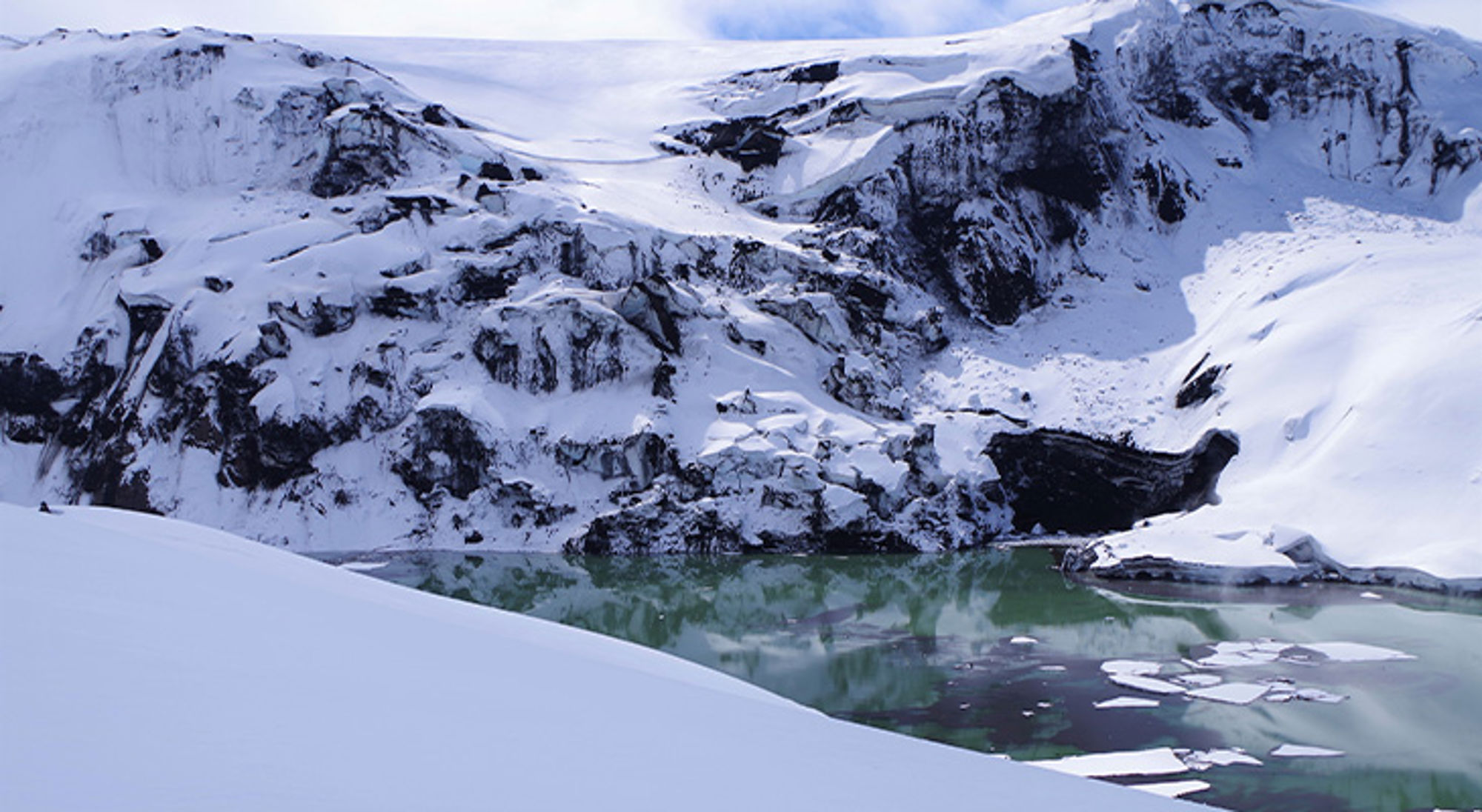 Grímsvötn vulkaan IJsland Besneeuwde bergen met een deels bevroren gletsjermeer en drijvende ijsschotsen.