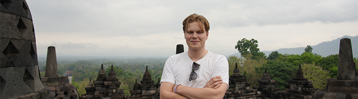 Olivier bij de Borobudur-tempel in Indonesië, met uitzicht over het groene landschap.