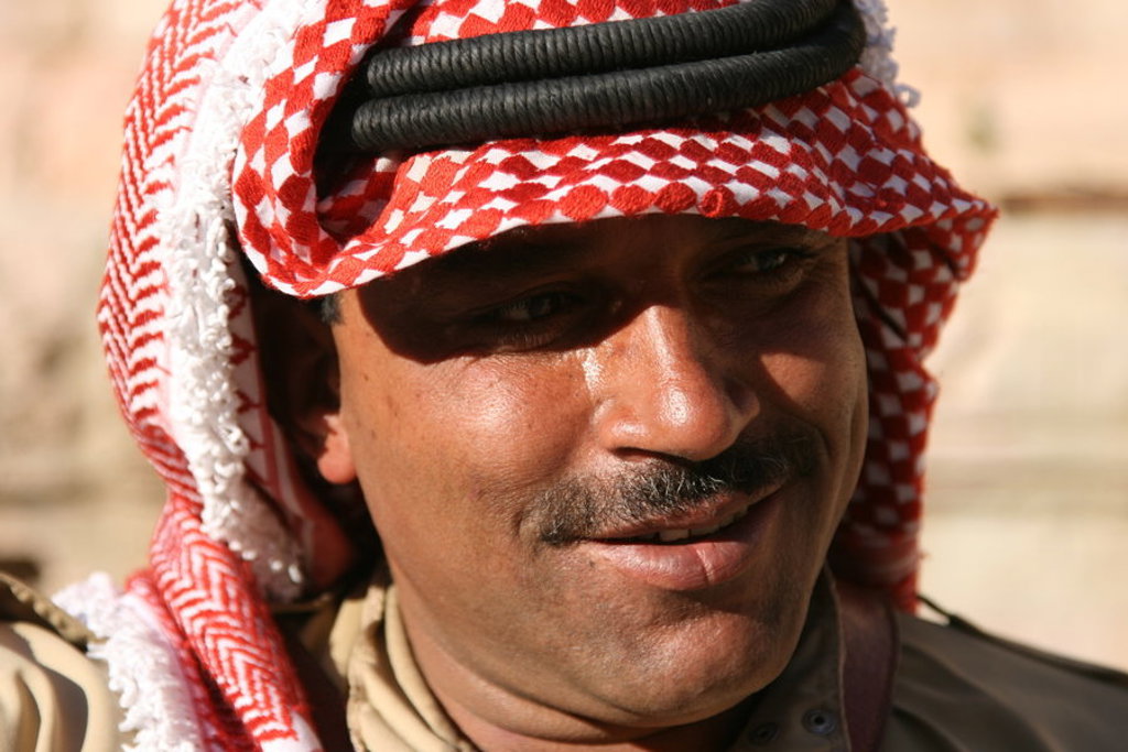Portret van een Jordaanse man met rood-witte keffiyeh tijdens de groepsrondreis Jordanië Hoogtepunten.