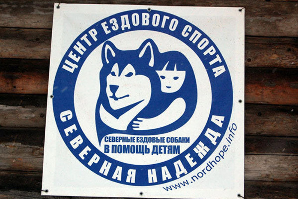 Russisch bord met husky en kind, symbool voor noordelijke sledehonden tijdens groepsrondreis Rusland in de winter.