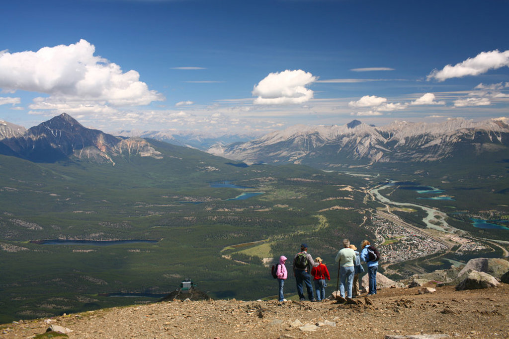 Uitzicht over de Rocky Mountains bij Banff met wandelaars op een bergtop tijdens groepsrondreis Canada West.