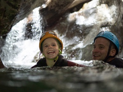 Kind en volwassene met helm in een rivierkloof bij Rio Cinca tijdens familiereis in Aragon, Spanje.