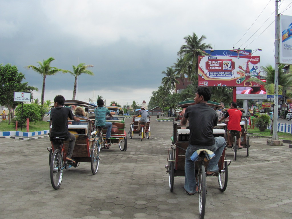 Becaks op straat met palmbomen in de stad tijdens groepsrondreis Sulawesi, Indonesië.