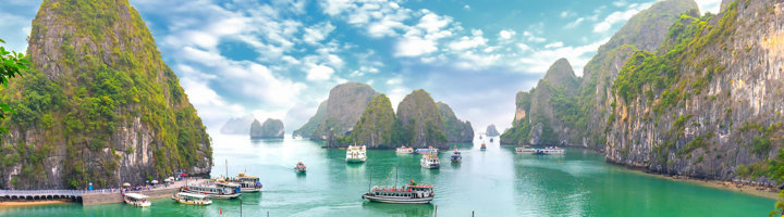 Panorama van Ha Long Bay met kalkstenen rotsen en boten op het turquoise water in Vietnam.